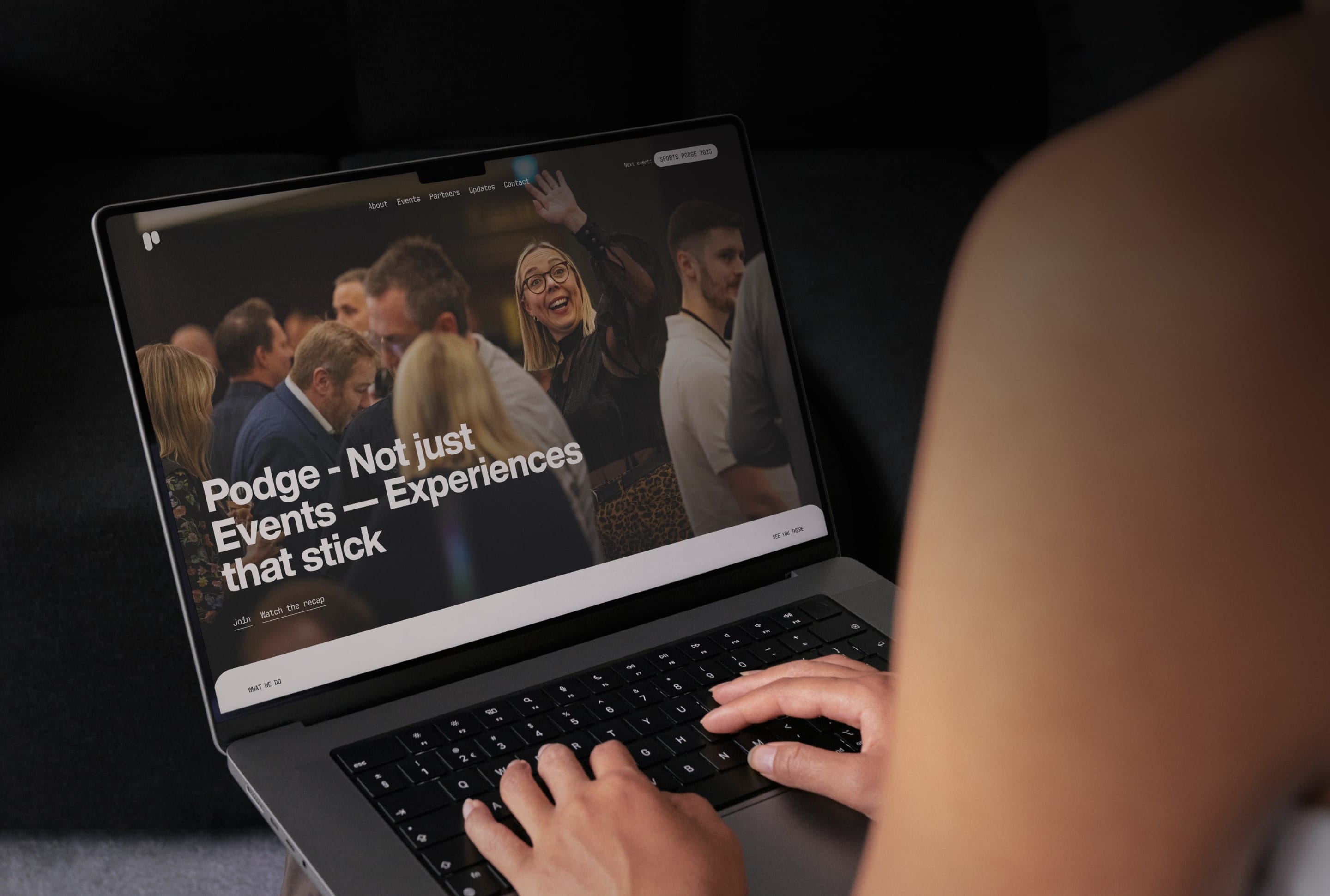 Person viewing Podge - Not just Events website on a laptop, emphasizing memorable experiences.